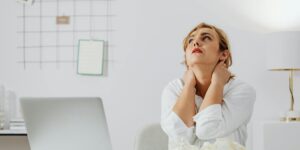 woman in white long sleeve shirt sitting at a table looking up